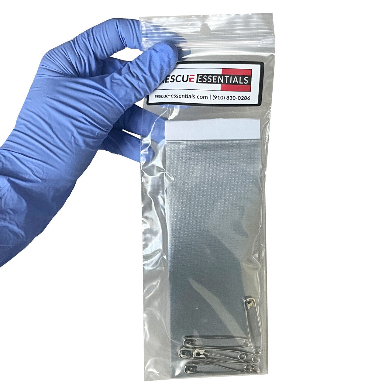 Pocket Tape w/Safety Pins in packaging being held in hand