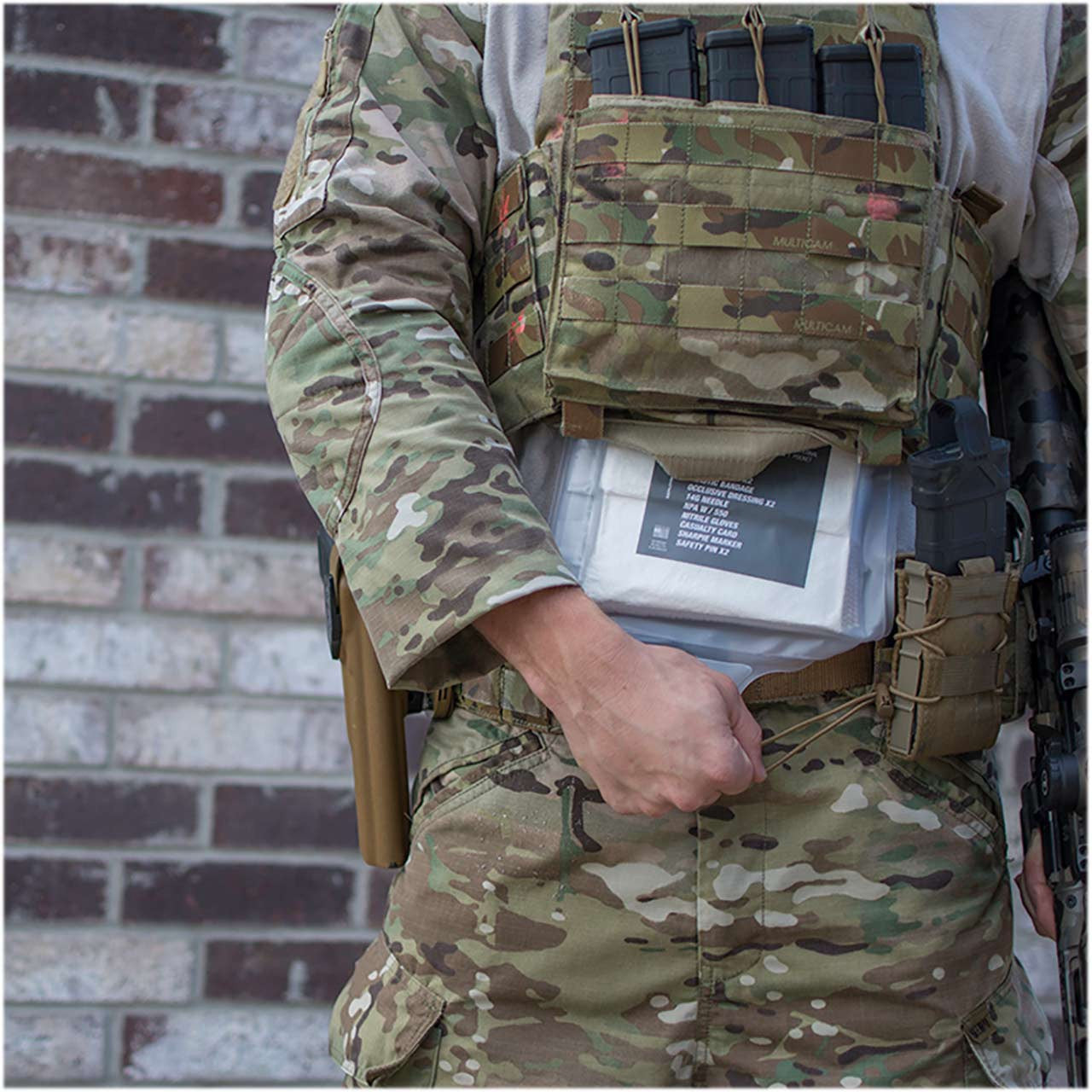 Deployment Trauma Kit II with External Pill Pouch by Phokus Research, being pulled from under armor