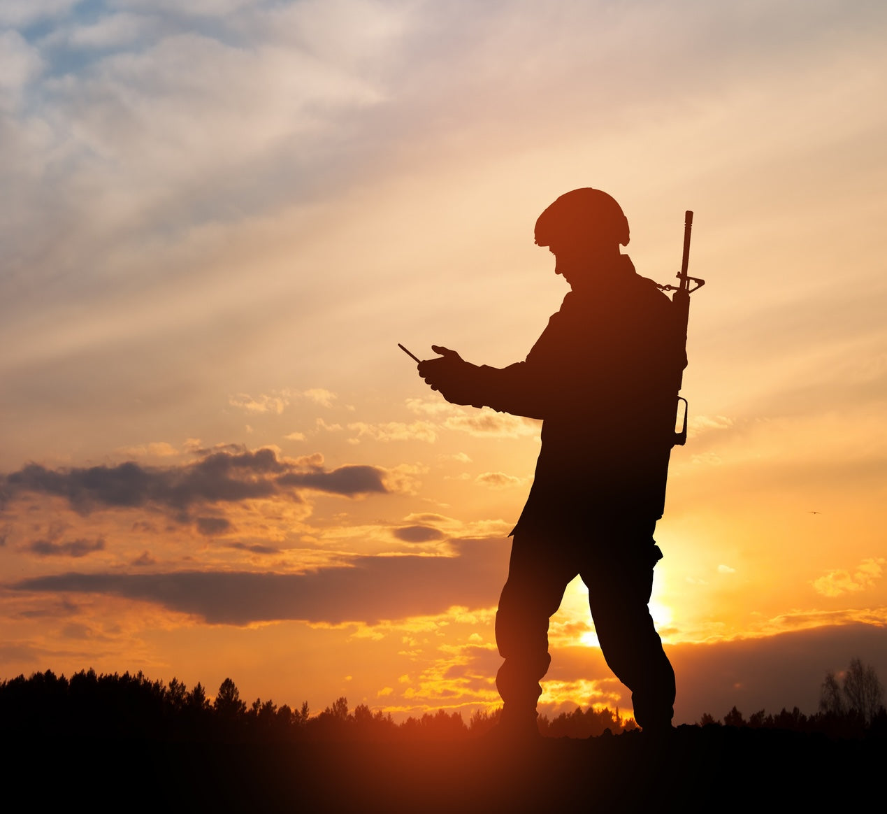 Silhouette of soldier are using drone and laptop computer for scouting during military operation. stock photo